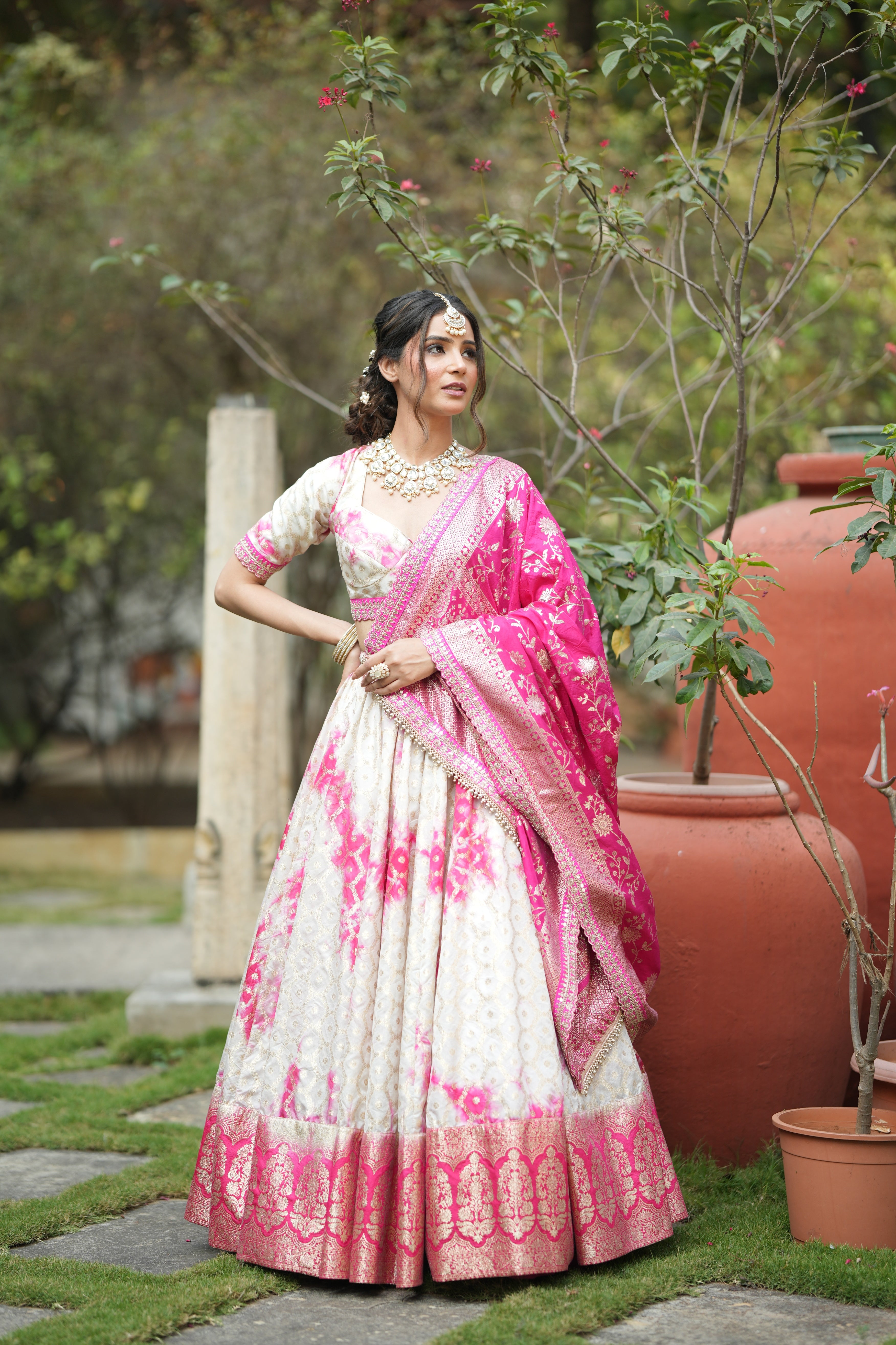 Front view of designer Banarasi silk lehenga for wedding with pink-white tie-dye and zari border – perfect bridal and party wear ensemble.