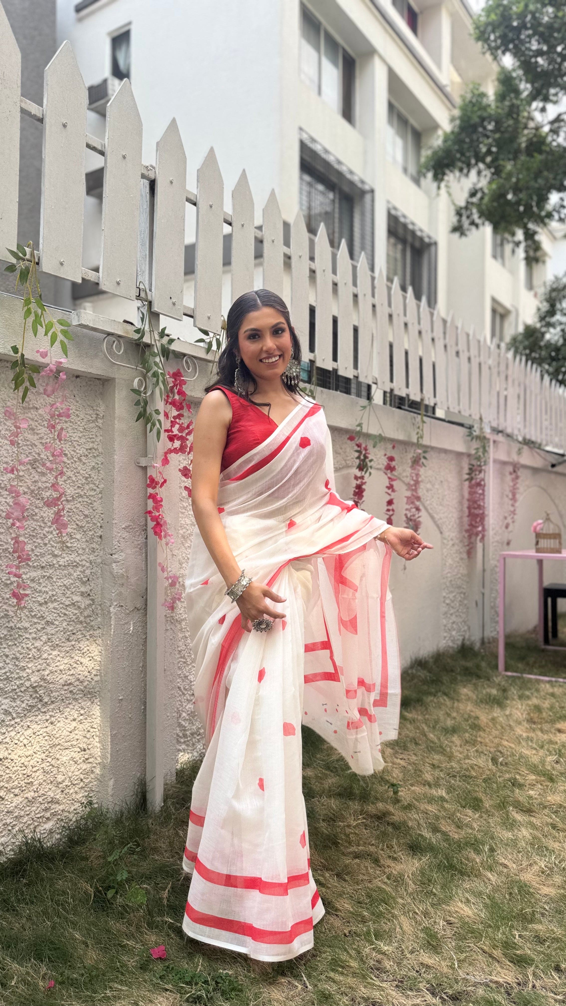 Woman wearing a red and white designer cotton saree with MAA print on the pallu