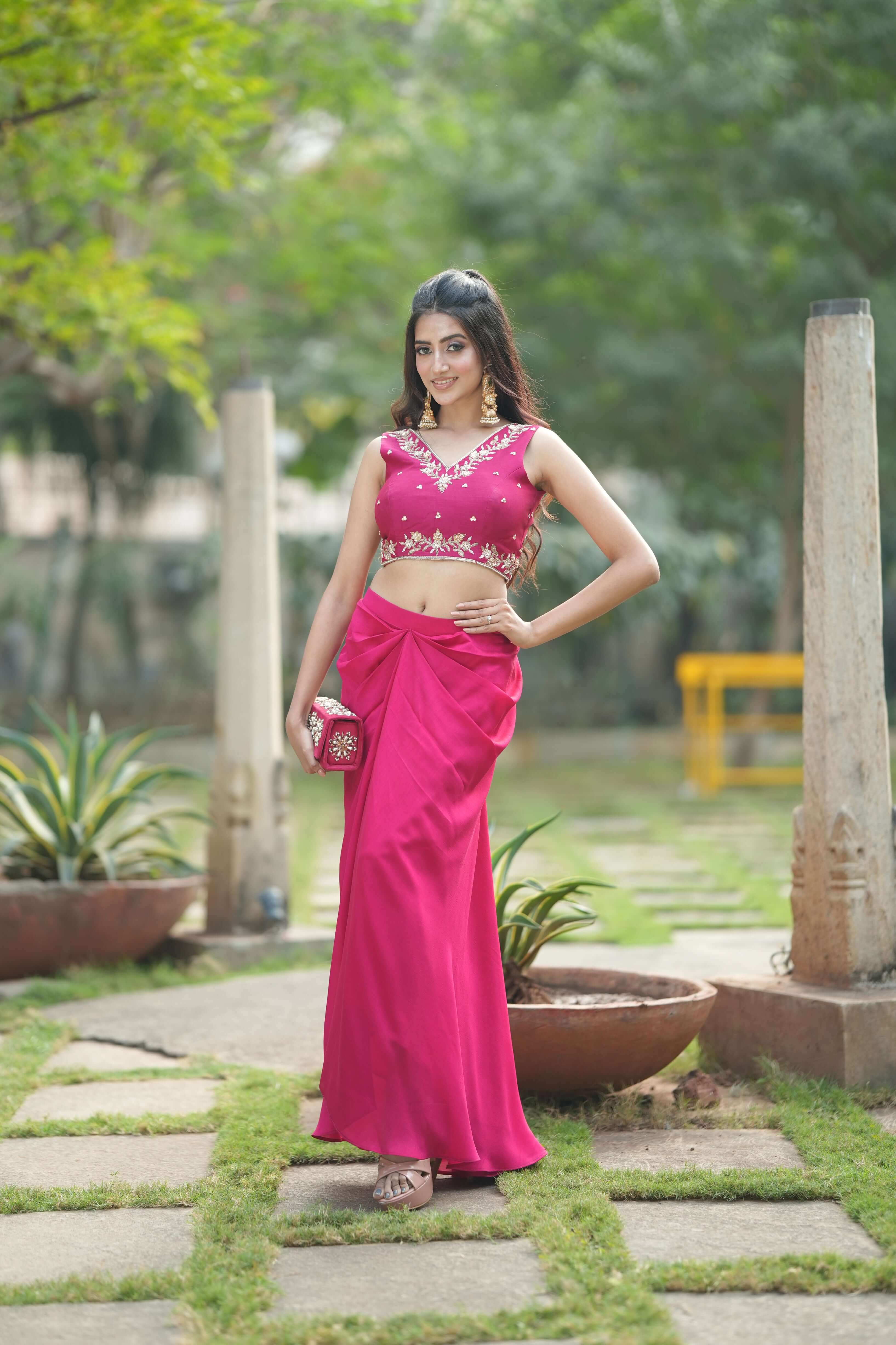 Model wearing a chic embroidered red dhoti set outdoors, showcasing modern Indian fashion with elegance.