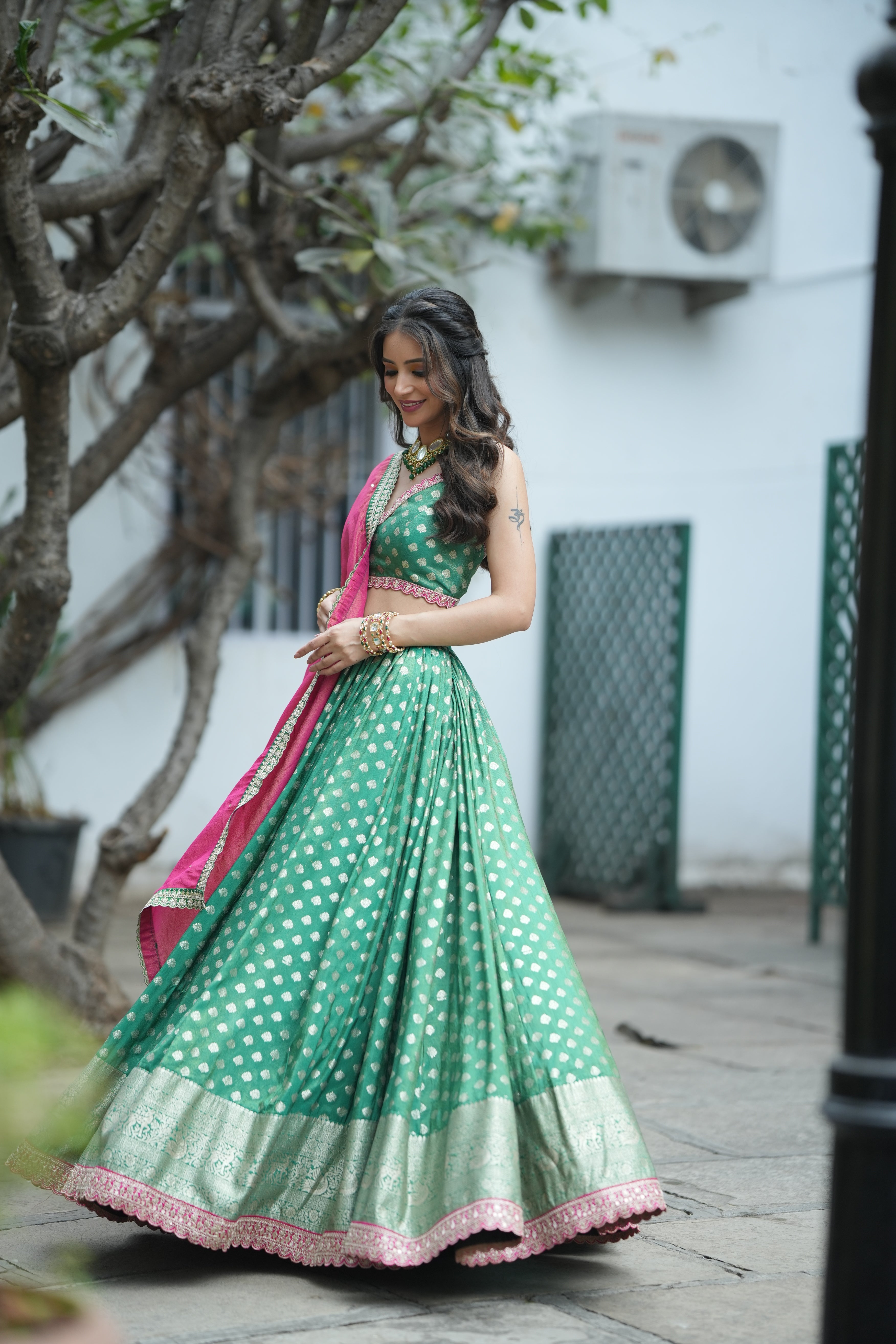 Emerald Opulence Green Banarasi Lehenga featuring intricate golden zari buti patterns and a modern crop top blouse.