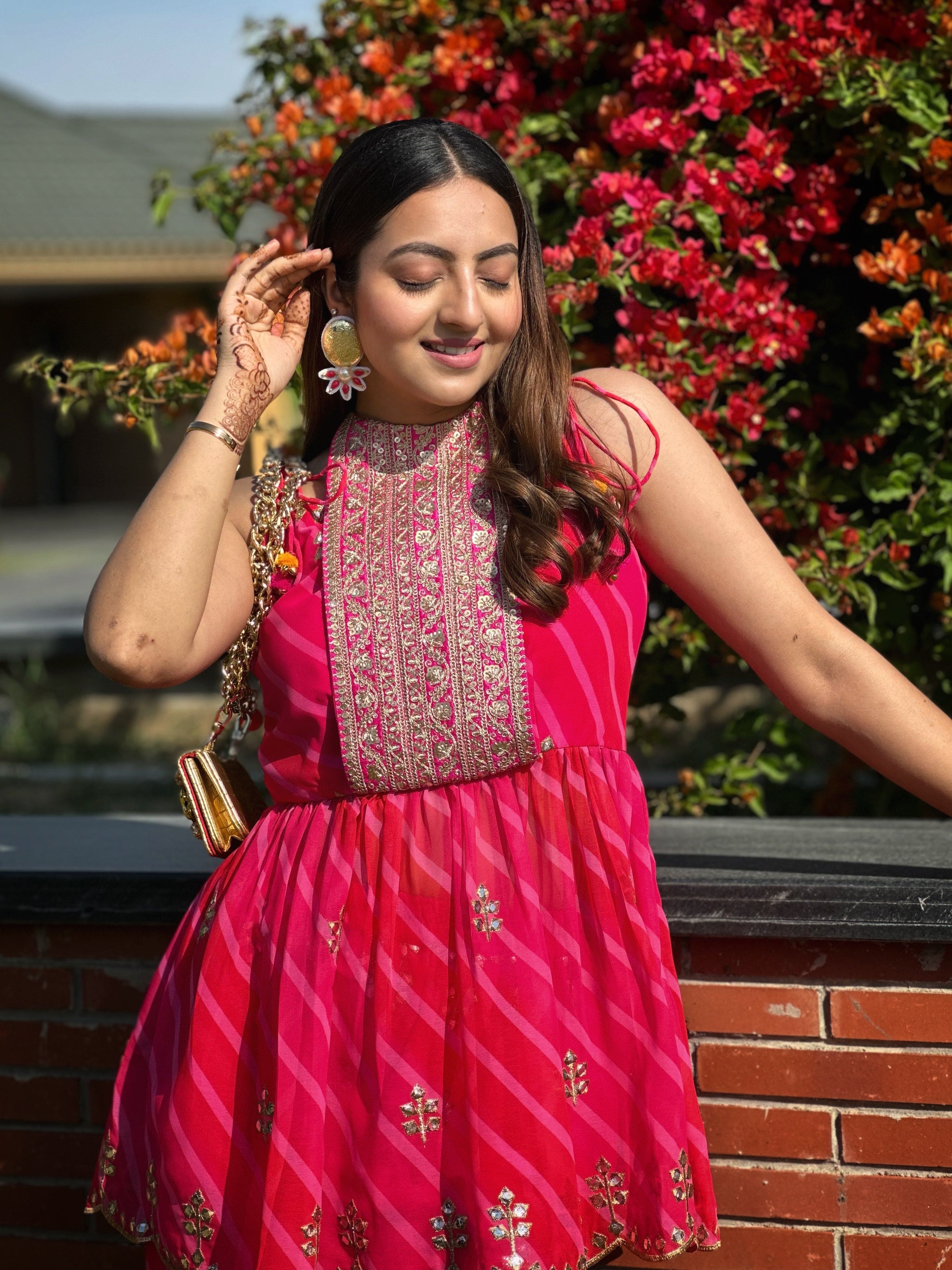 Woman wearing fuchsia Lehariya kurta set with sleeveless peplum and palazzo pants