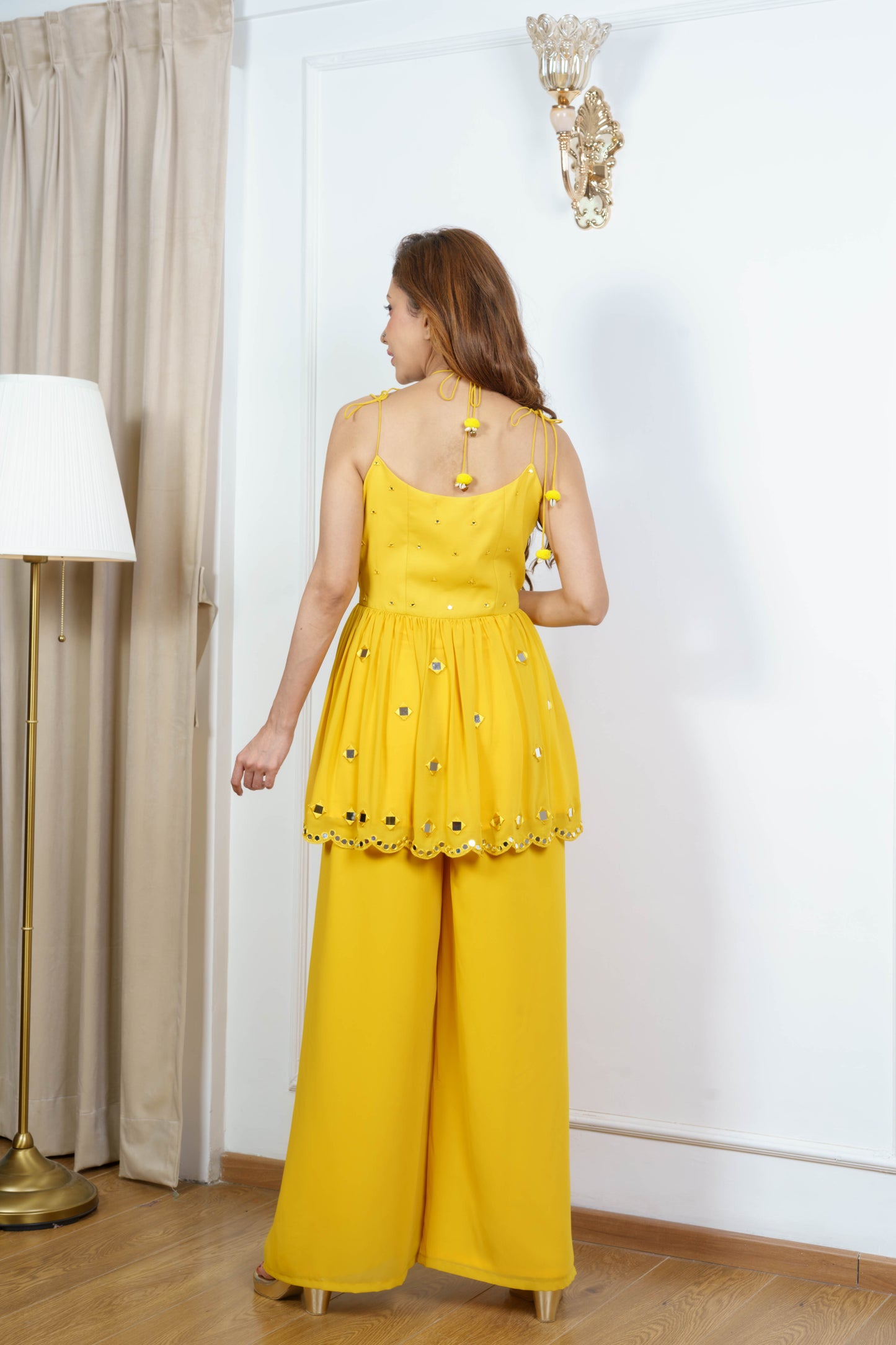 Sleeveless mustard kurta set for women with tie-up detail ?back view.