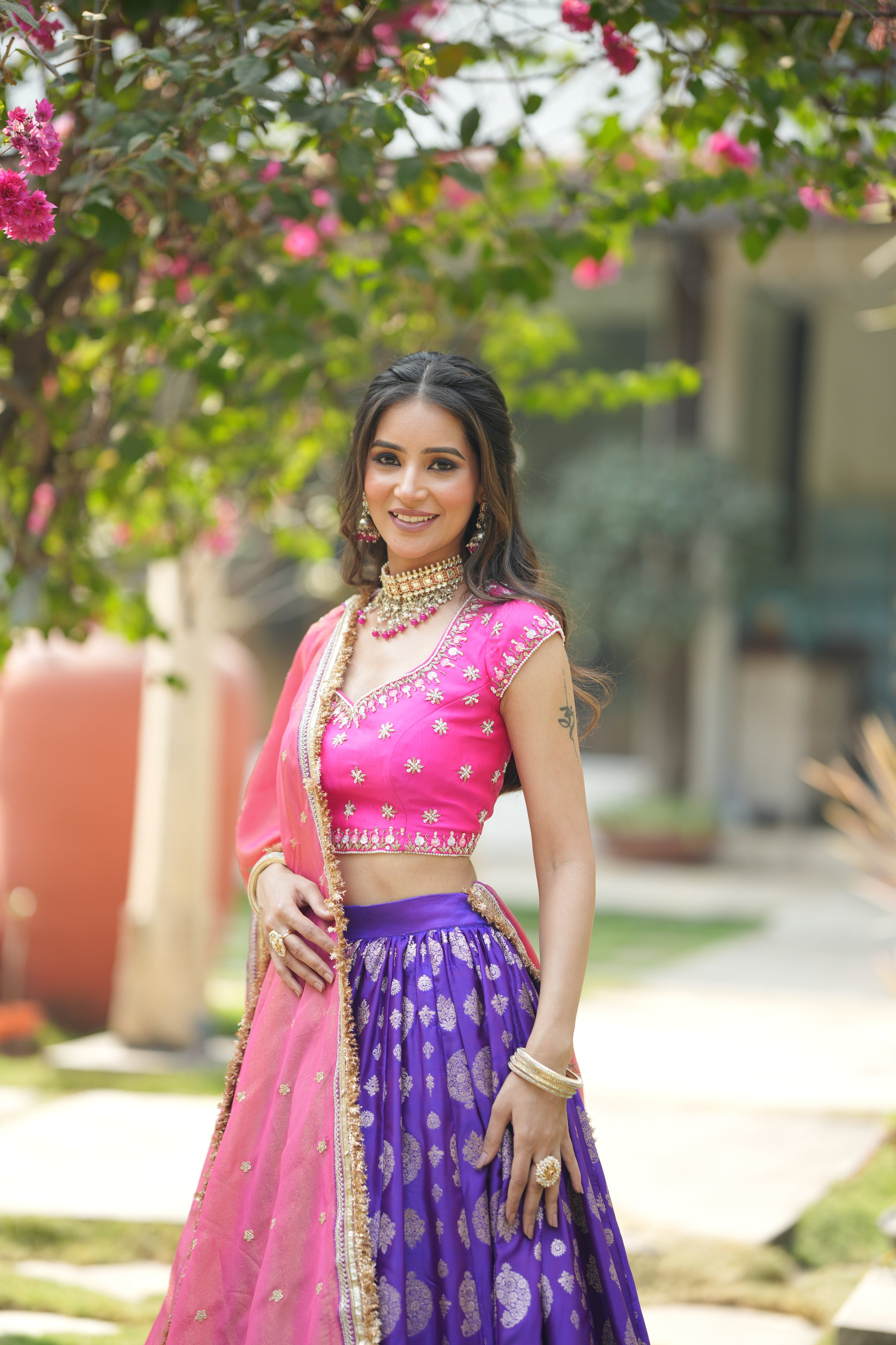 Front view of pink and purple Banarasi lehenga choli with embroidered blouse and organza dupatta