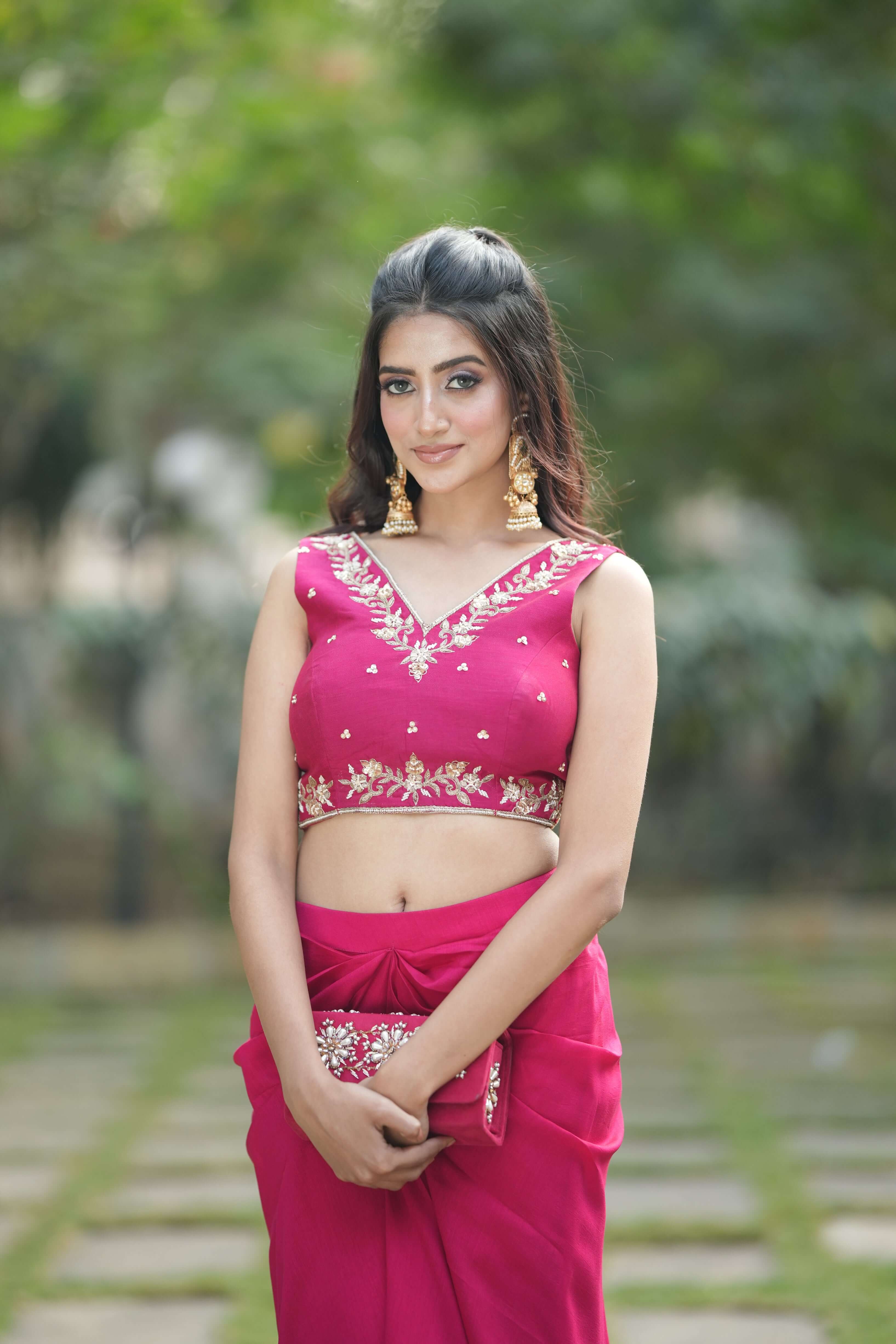 Beautiful model in vibrant red embroidered dhoti set with elegant accessories, showcasing modern Indian fashion.