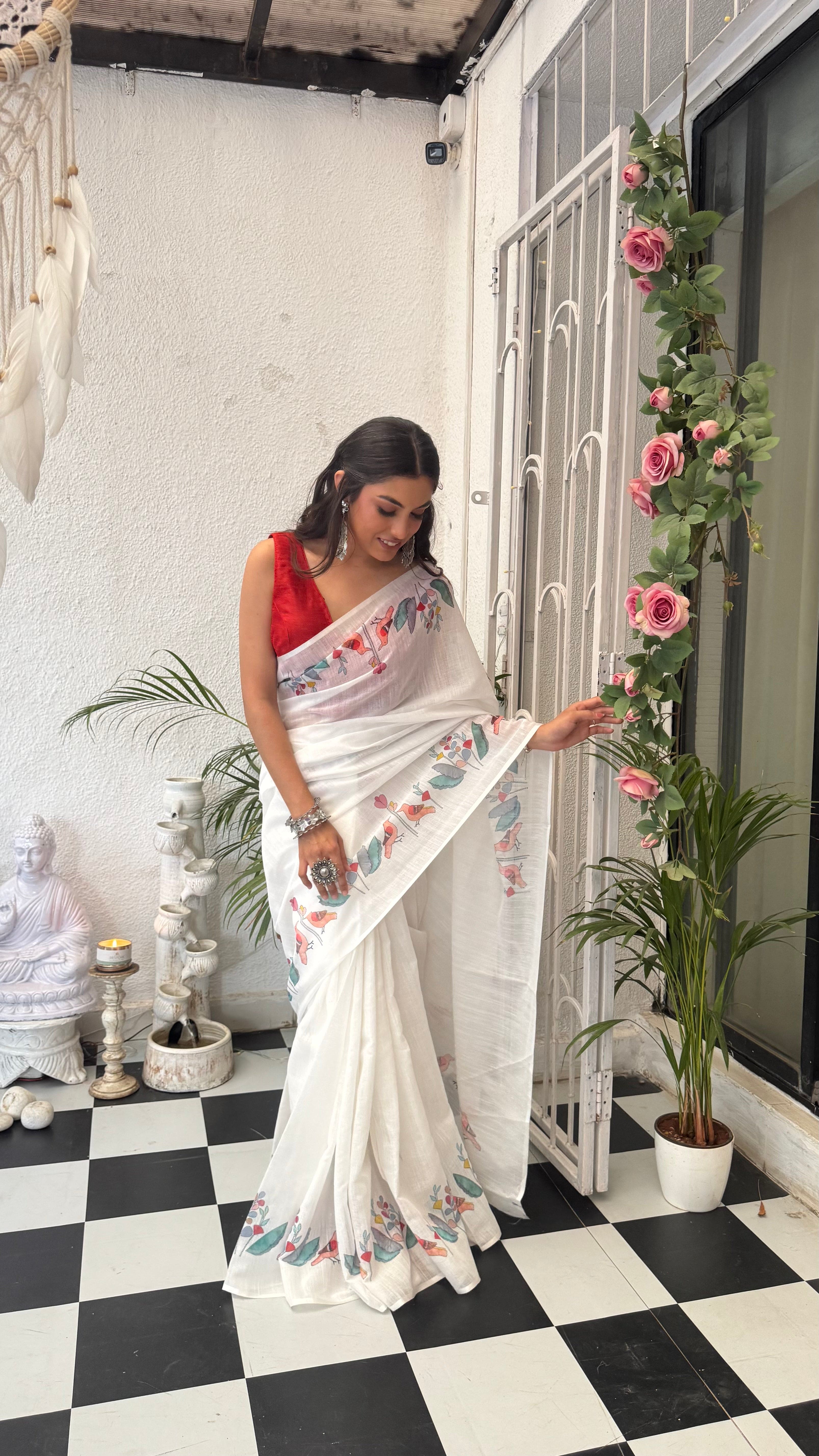 Woman wearing white floral designer ethnic cotton saree with soft drape and artistic border