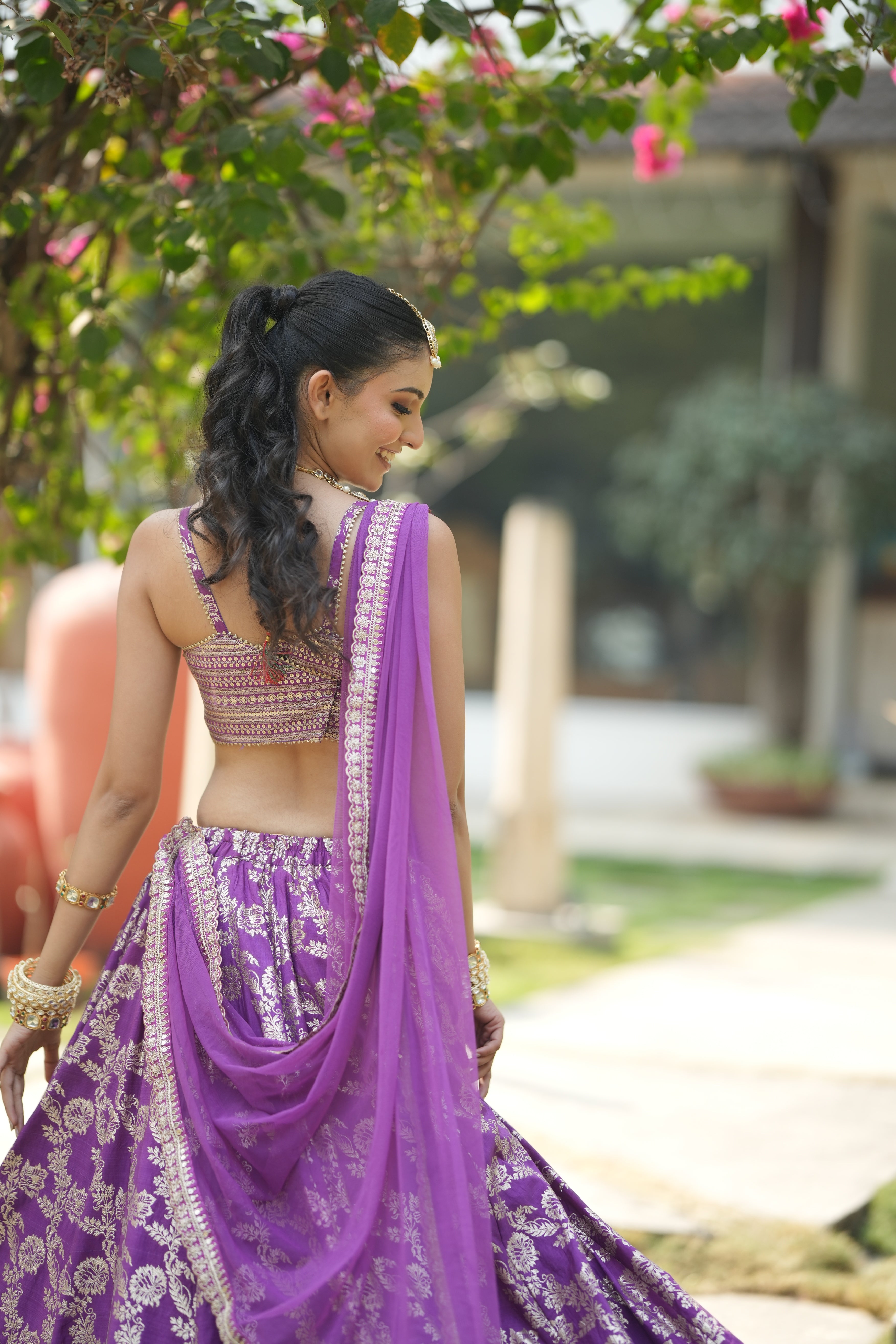 Back view of lavender zari work lehenga set with detailed embroidery and blouse design.