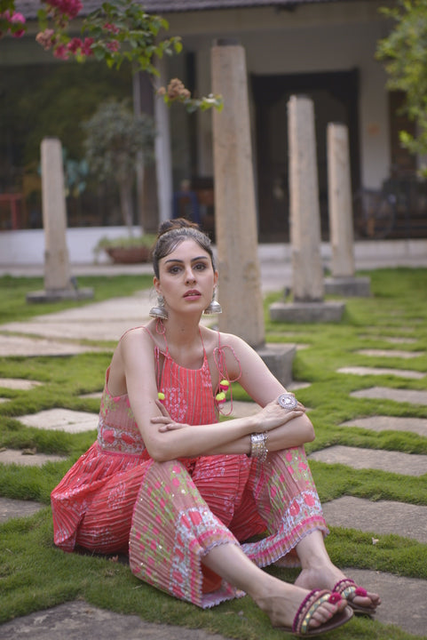 Orange sleeveless peplum kurta with tassel tie straps and floral detailing
